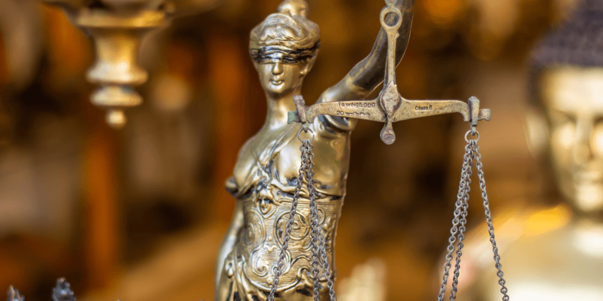 Bronze statue of Lady Justice holding scales, symbolizing law and fairness