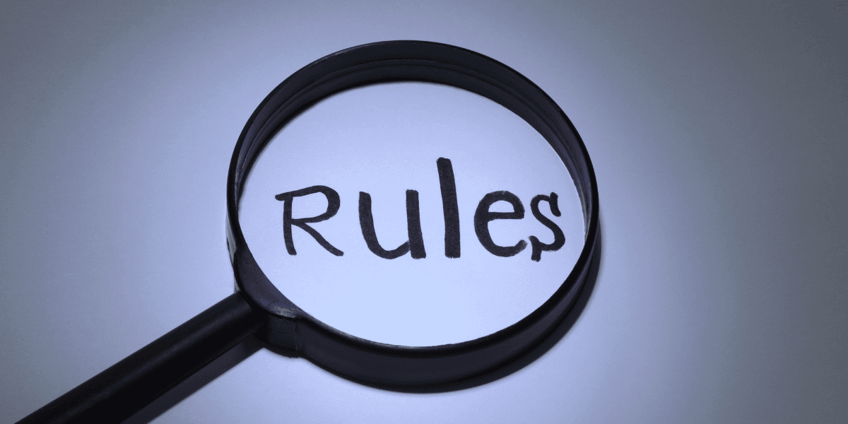 A magnifying glass highlighting the word "Rules" on a white surface