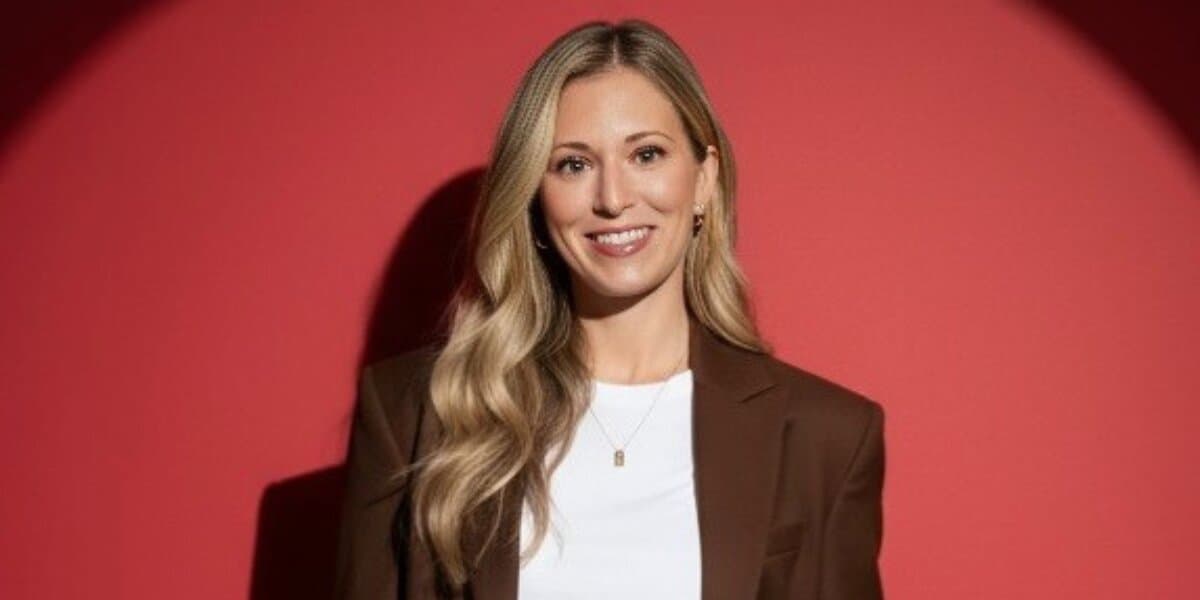 Professional portrait of Jaime Weiland smiling against a red background, highlighting her healthcare education and consulting work.