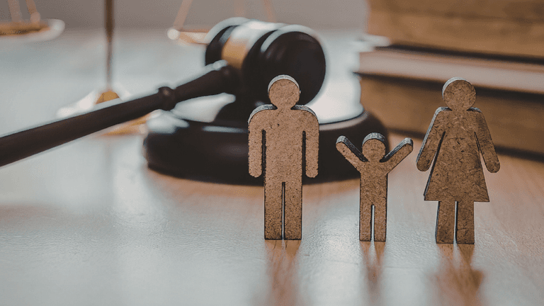Figures representing a family with a gavel and law books in the background