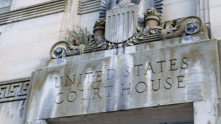 Detail of a United States Courthouse entrance with decorative stonework and an eagle emblem