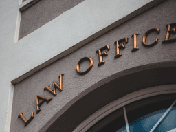 Exterior of a building featuring a sign that reads "Law Offices" in gold lettering