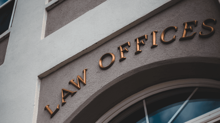 Exterior of a building featuring a sign that reads "Law Offices" in gold lettering
