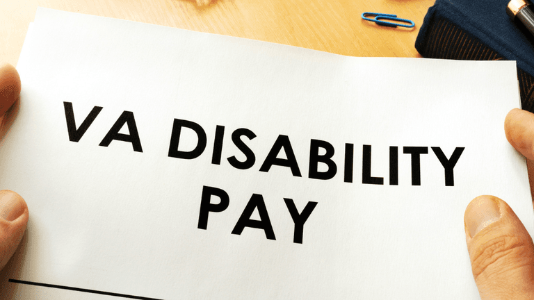 Person holding a paper with the words VA DISABILITY PAY in bold text