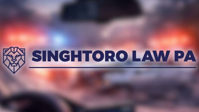 Singh Toro Law PA logo over blurred accident scene background with emergency lights.