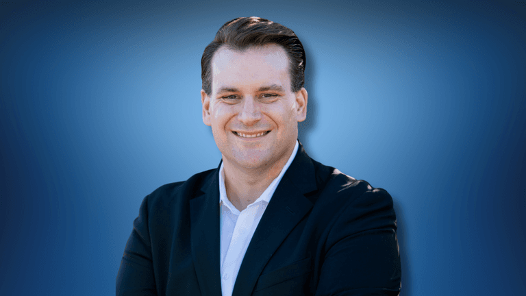 Man in a suit smiling confidently, representing attorney Travis Vernier of Bennett | Vernier law firm.